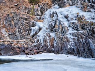 Fototapeta na wymiar icy cliff on a canyon of mountain river in winter scenery - Poudre River at Little Narrow above Fort Collins, Colorado