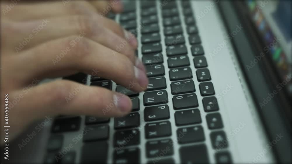 Poster working online on the keyboard of a laptop. stock footage. close up of male hands typing text on the