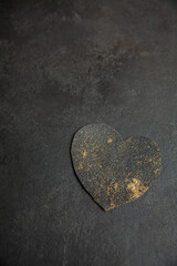 Gold vintage heart on dark textured background, clouseup. Card, handmade. Empty place. 