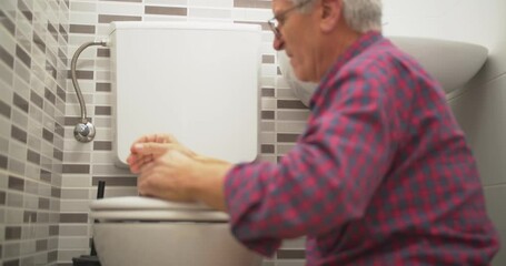 Adult handyman fixing the toilet