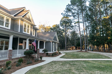 Front view of a large two story blue gray house with wood and vinyl siding