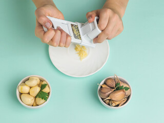 A girl rubs garlic on a blue background.