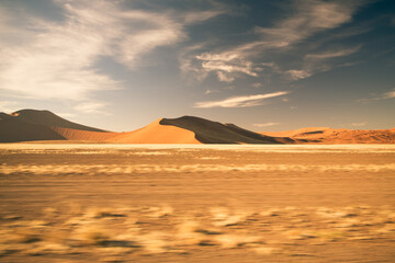 Fototapeta na wymiar Desert landscape with sand dunes and wispy clouds