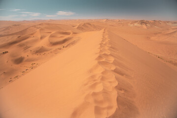 Hiking ridge on top of huge dune in desert landscape