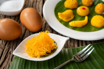 Foi thong or Golden thread (Thai dessert) on a white plate with banana leaves.