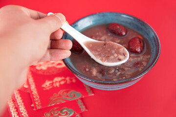 Red envelope and eight treasures porridge on red background