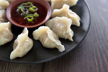A plate of boiled dumplings and dip