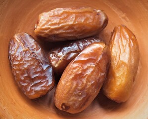 dried dates cut on clay cup on a white background.