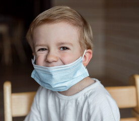 a boy sitting in a medical mask