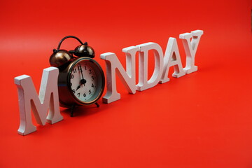 Monday alphabet letter with alarm clock on red background