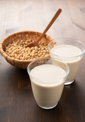 Soy milk in a glass on a wooden background