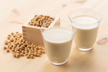 Soy milk in a glass on a wooden background