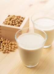 Soy milk in a glass on a wooden background