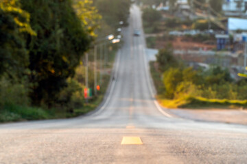Blur of the asphalt road downhill and uphill to the end of sight for background.
