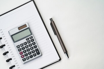 Top view of notebook with pen and calculator with white isolated background 