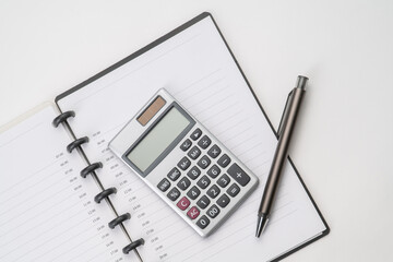 Top view of notebook with pen and calculator with white isolated background 