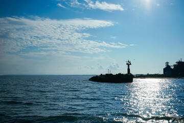 Obraz premium Seascape with a silhouette of a lighthouse and a coastline.