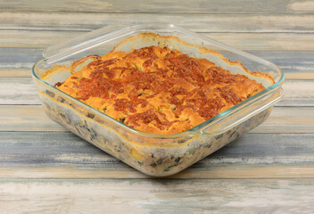 Baked beef and vegetable casserole with cheddar cheese biscuit crust in glass baking dish