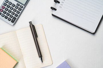 Top view of notebook with pen, sticky note  and calculator with white isolated background 