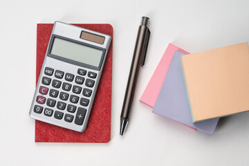 Top view of notebook with pen , sticky note and calculator with white isolated background 