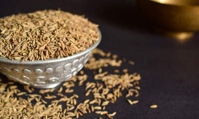 Top View Closeup Cumin seeds in a Silver Bowl on On isolated Black Background