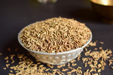 Top View Closeup Cumin seeds in a Silver Bowl on On isolated Black Background