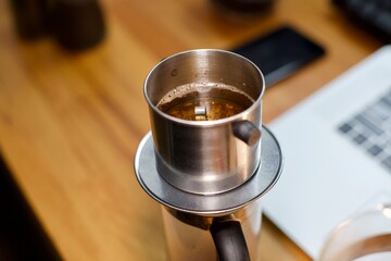 cup of coffee on the table. brewing coffee using phin filter. it is traditional Vietnamese Coffee