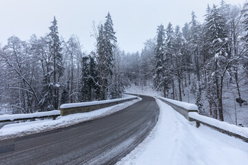 Wild river in winter with old stone arched bridge.
Beautiful frosty day. Snowy weather in mountain....