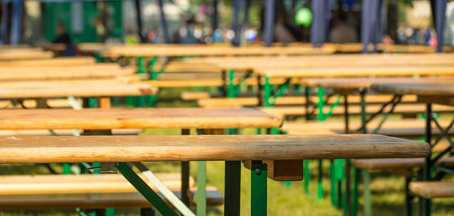 Fototapeta na wymiar In einem Biergarten stehen Tische und Bänke. Die Tische sind leer, das Restaurant ist geschlossen.