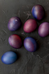 Painted blue and purple Easter eggs on a textured background. Easter eggs on a plate.