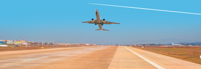 White Passenger plane fly up over take-off runway from airport 
