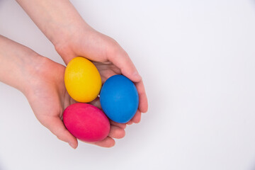 Fototapeta na wymiar Children's hands are holding colored Easter eggs.
