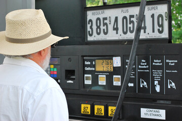 Male senior at the gas pump.