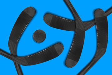Five hockey sticks and a puck on a blue background