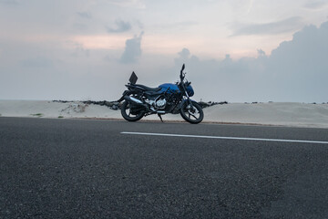 motorcycle isolated standing on tar road in sea shore background