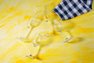 empty drinking glasses on yellow background with hard shadows and sun glare. sober concept. the...