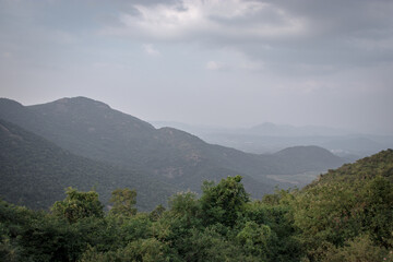 Fototapeta na wymiar Mountain range with green forests and blue sky