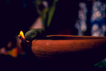 Creative Photography of A Realistic Burning Clay Oil Lamps in Diwali, An Indian Festival in Evening. Colorful Red, Yellow Orange Fire Flame Lit on Dark Night Shadow Background with Noise Grain Effect.