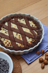 Chocolate shortcrust pastry filled with ricotta cheese and chocolate pieces on wooden table