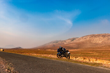 countryside empty rural road with motorcycle parked and surrounded by mountains at morning