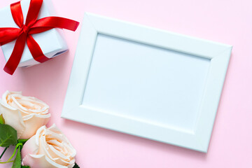 Valentine frame with sweet rose and gift box on pink background with copyspace for text.