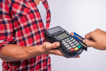 The store staff is swiping a credit card to pay for the product. Concept of payment using a debit...