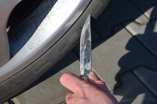 Man With A Big Hunting Knife In The Parking Lot Is About To Stab, Cut The Tire. Revenge To A Neighbor, Her Mistress's Husband, For Poor Parking At The Entrance, Envy Of A Nice Car, Terrorist Attack