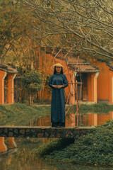 Beautiful Vietnam girl from Hue city, Vietnam who wearing Ao dai. Ao dai is famous traditional custume for woman in Vietnam. Vintage style,travel and relaxing concept.