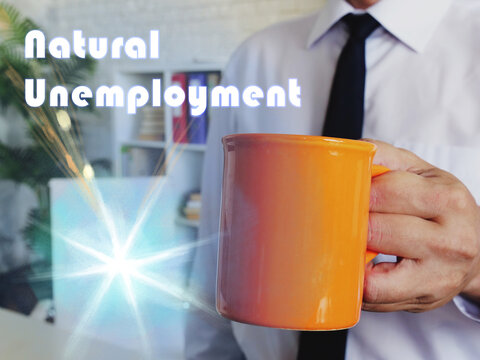 Business concept about Natural Unemployment with Man with a cup of coffee in the background.