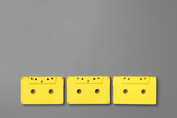 Yellow audio cassettes on gray background top view