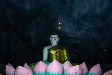 Budhha white isolated statue with golden contrast and crackers spark white smoke