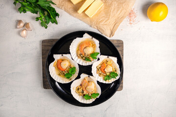 Baked scallops with caviar and creamy garlic sauce. Scallops, lemon, garlic, parsley, butter and salt. Recipe for cooking scallops with caviar. Top view. Copy space.
