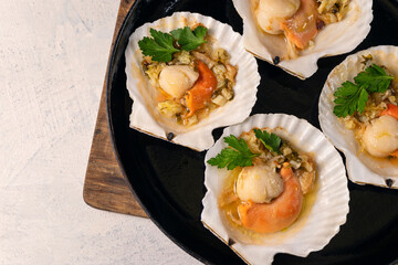 Close up baked scallops with caviar and creamy garlic sauce. Recipe for cooking scallops with caviar. Top view. Copy space.