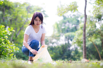 Woman hand picking up garbage plastic and Glass bottles for cleaning at park